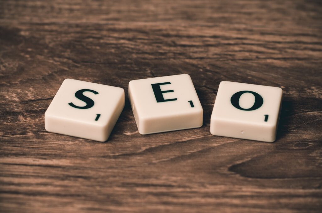 Three scrabble tiles spelling out SEO on a wooden table 