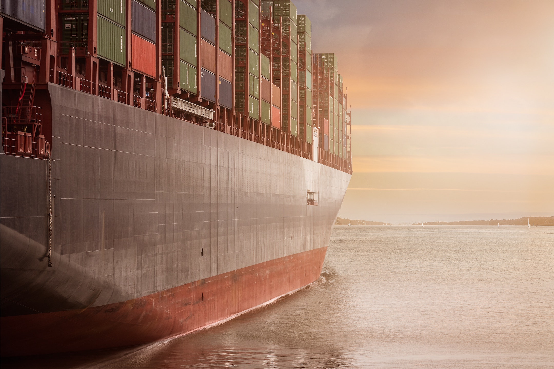 Large container ship on the sea with a beautiful pale sky behind