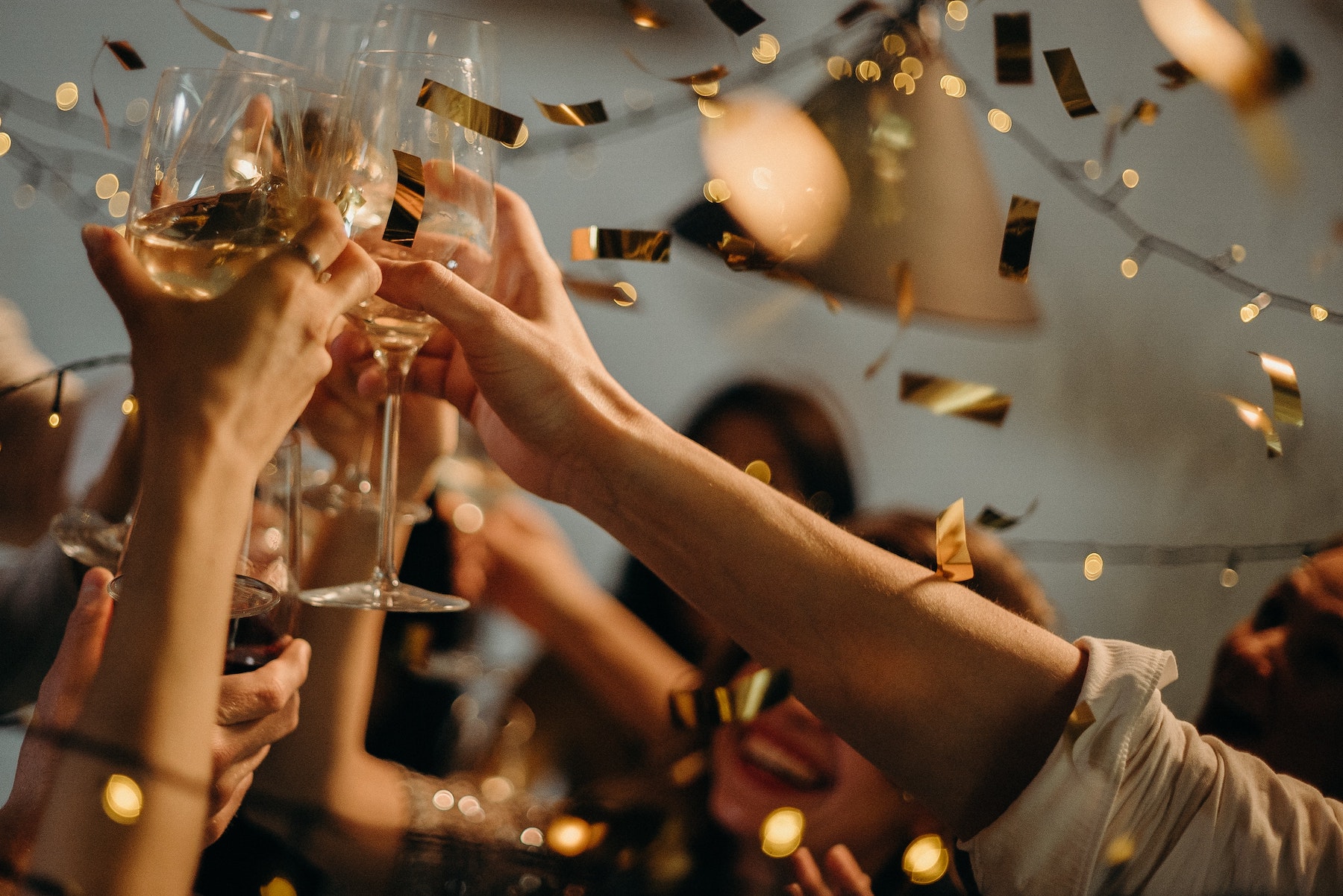 A crowd of hands holding champagne glasses raised in celebration