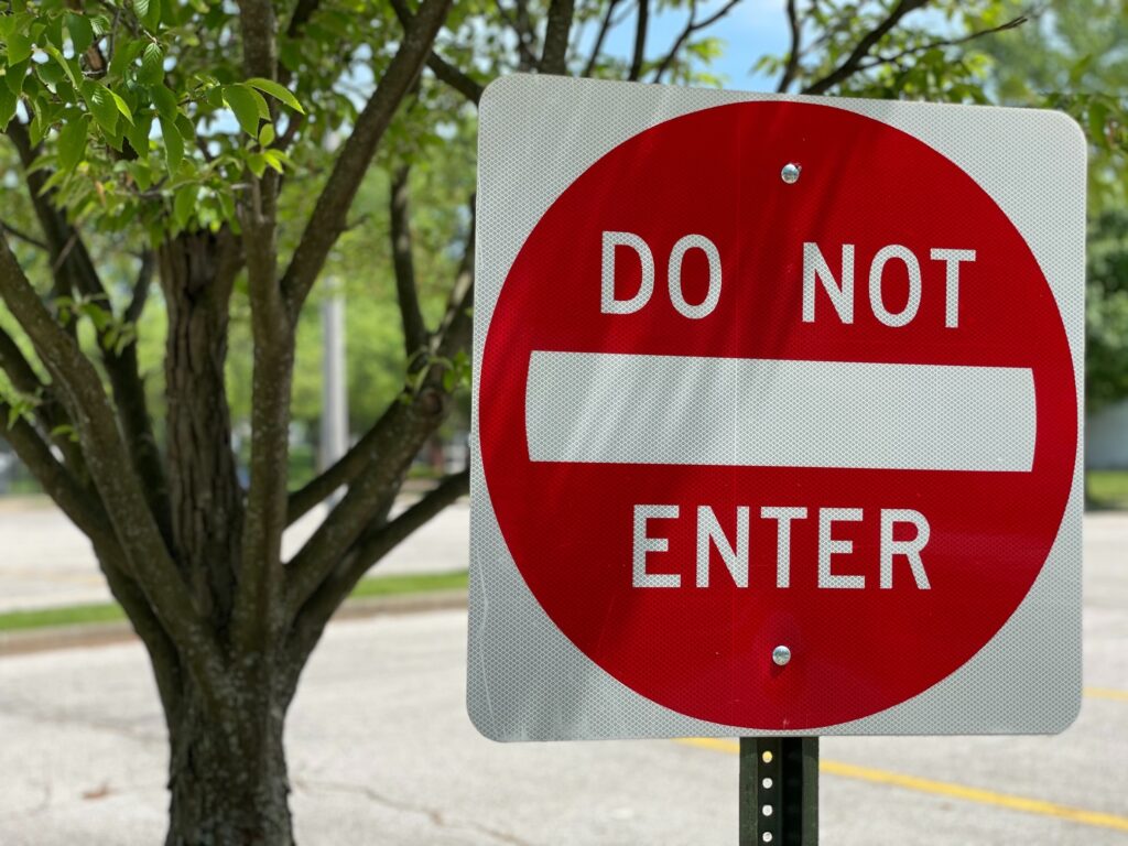 A city street with a red and white "do not enter" sign 