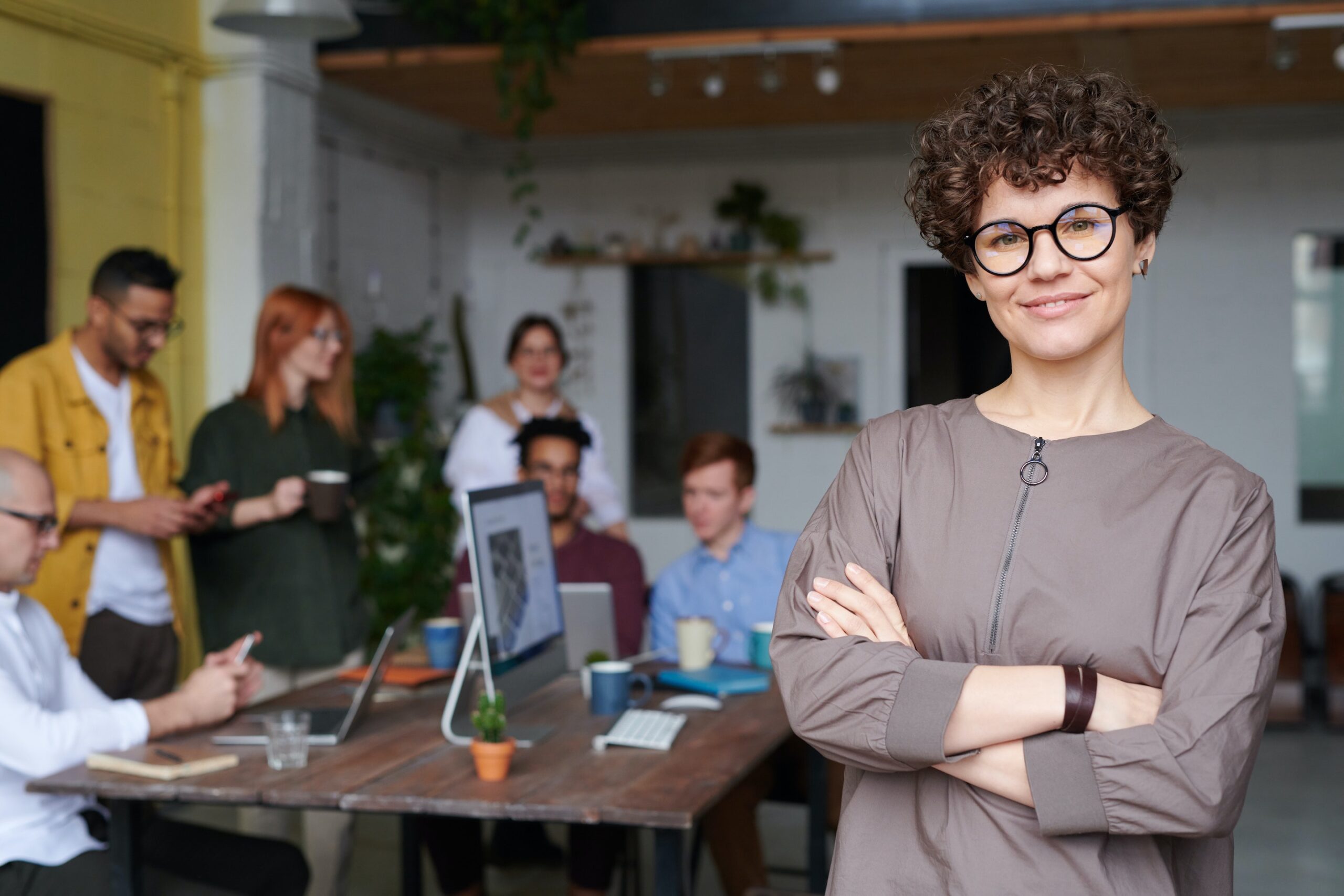 dark haired woman in front of table with colleagues