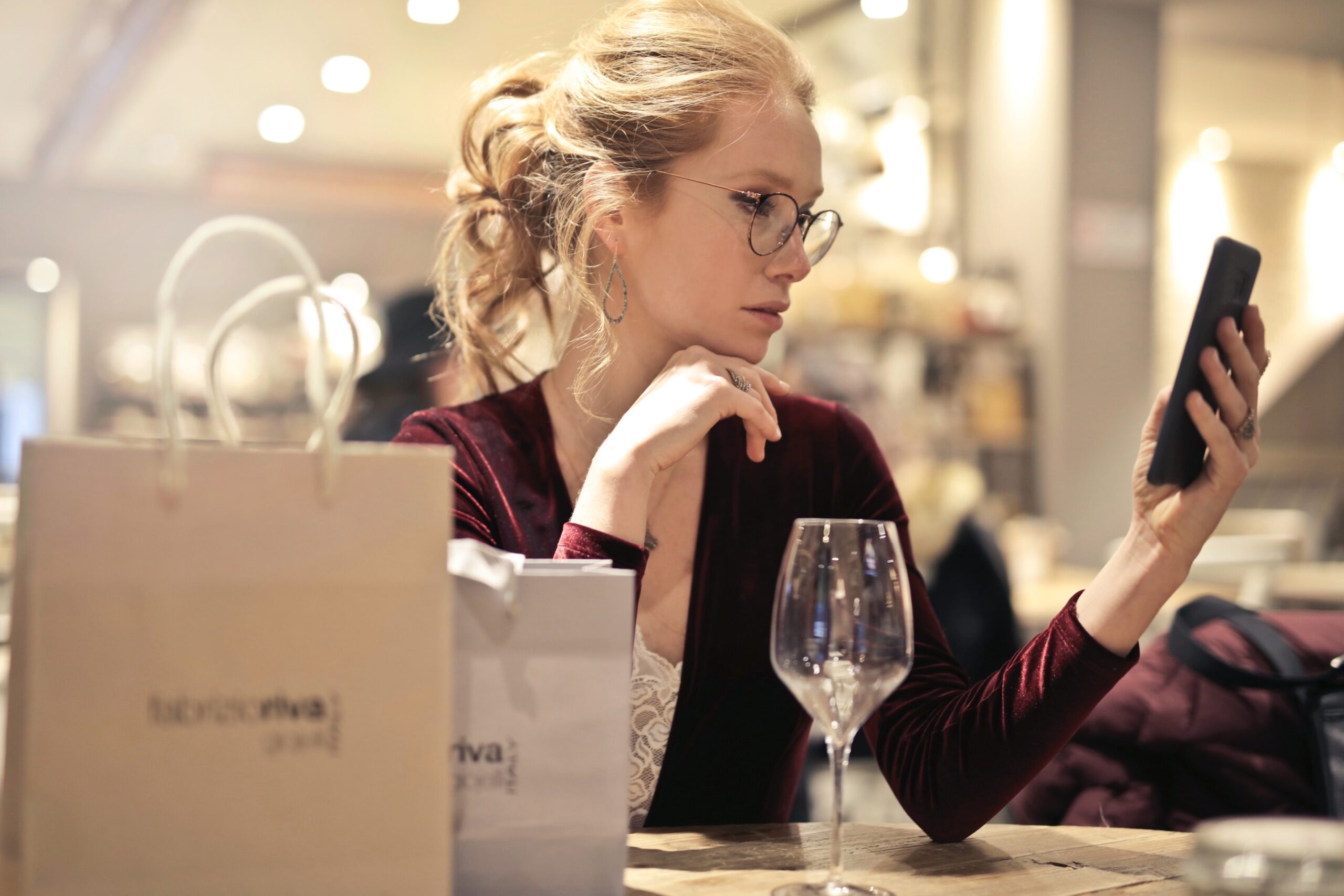 A woman shops on her mobile device in a well-lit store.