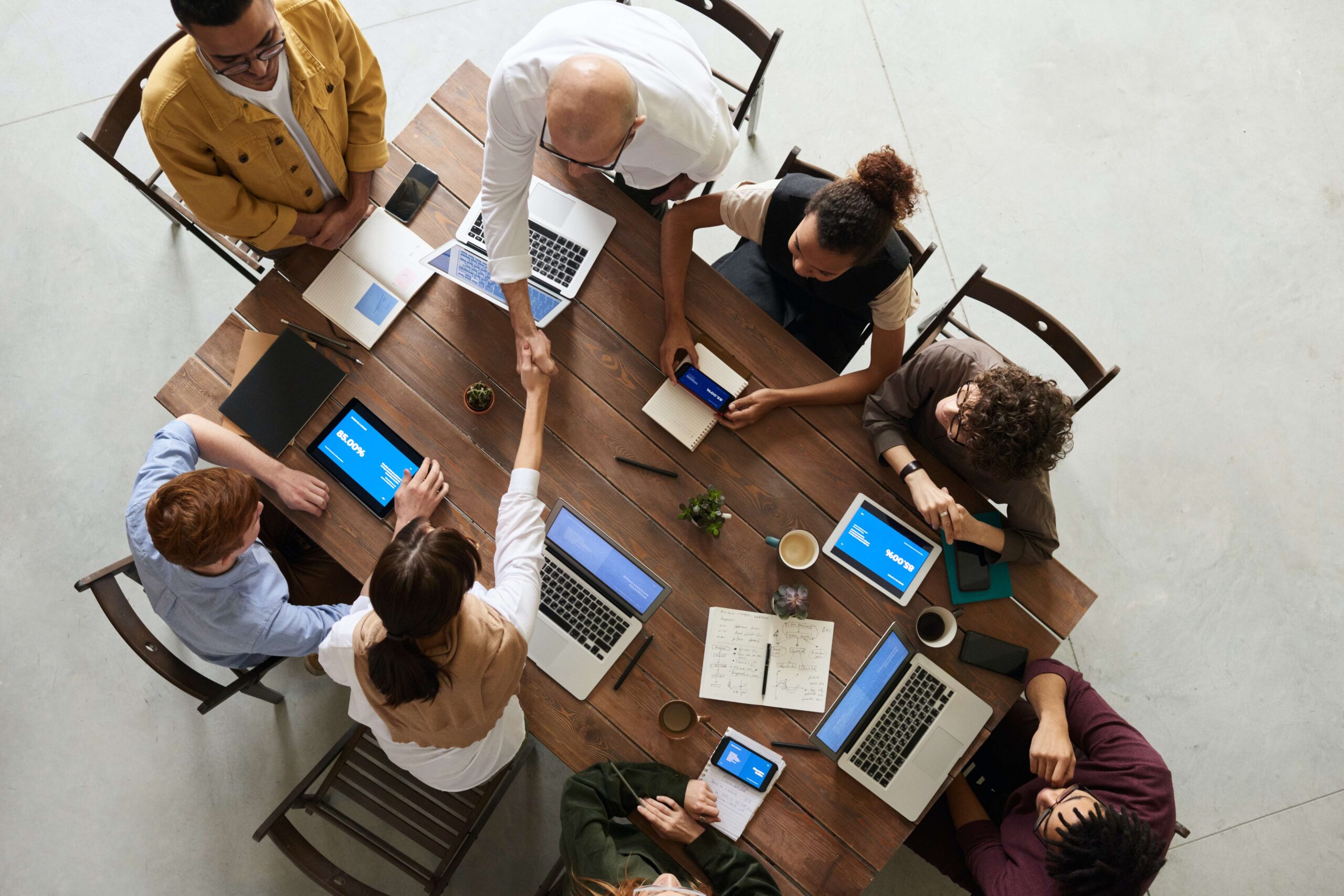 An overhead view of a team of professional business people sitting at a large table working