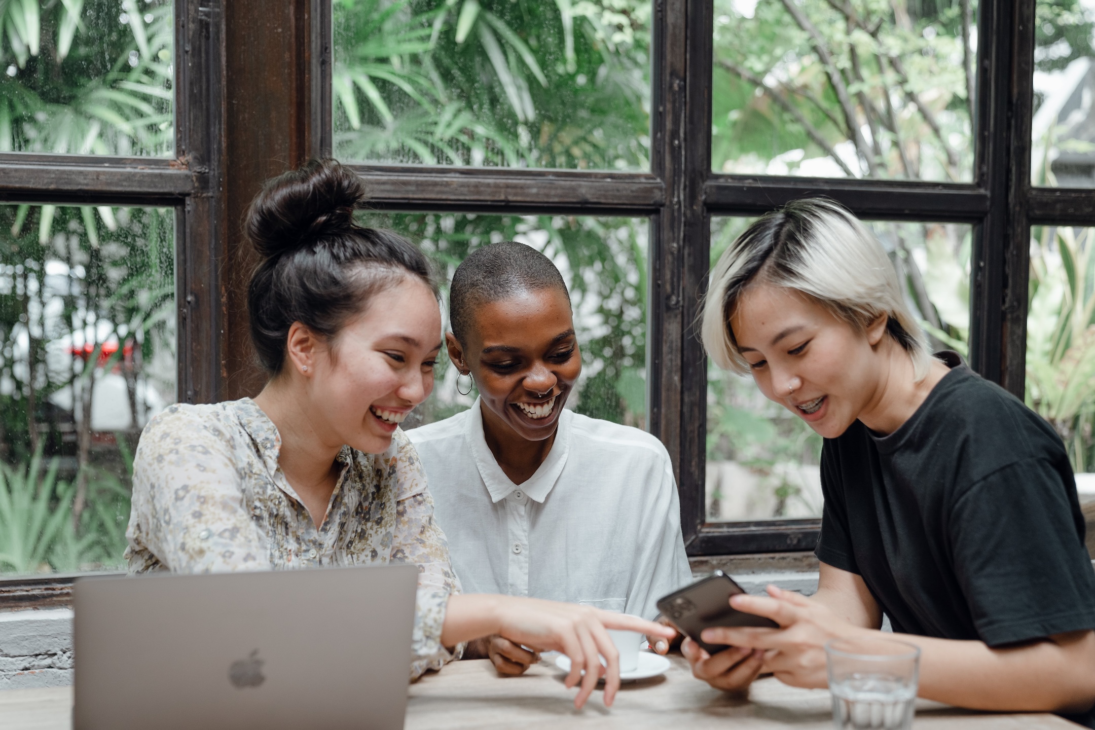 Three young people looking at an images on their phones