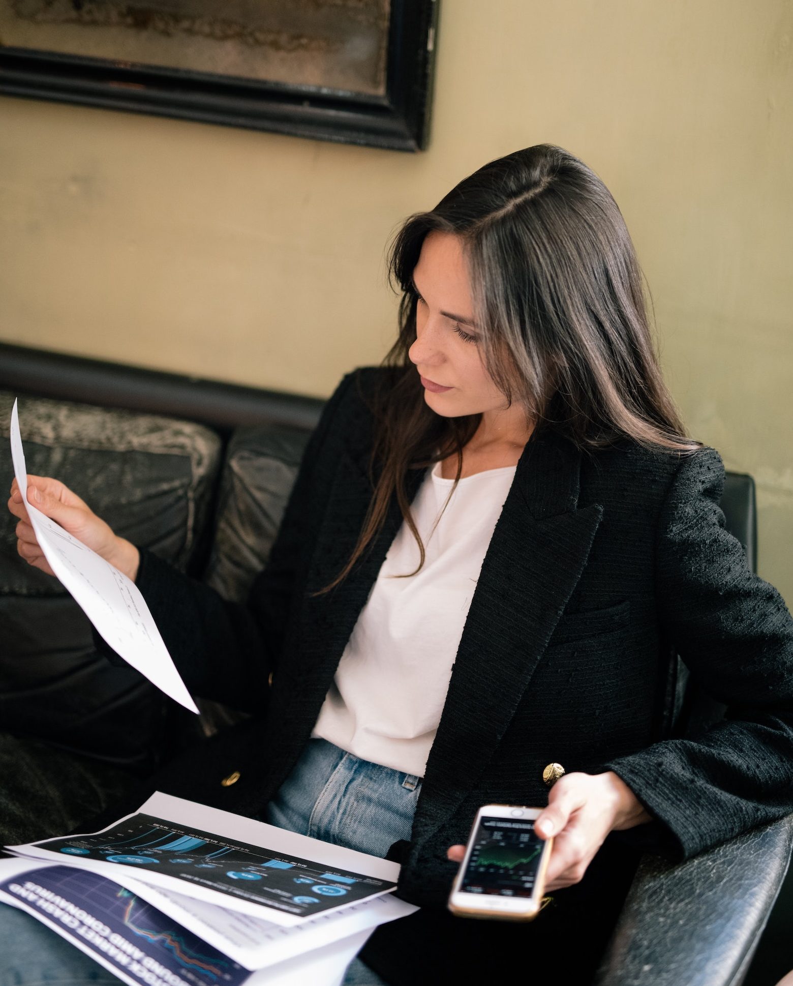 Beautiful dark haired woman reading a sheet of statistics