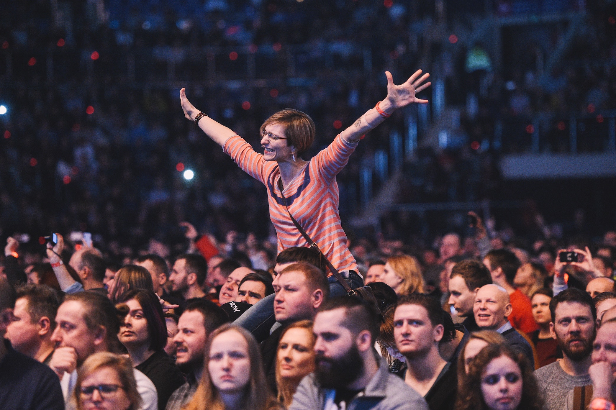 A crowd of people with a woman on the shoulders of someone